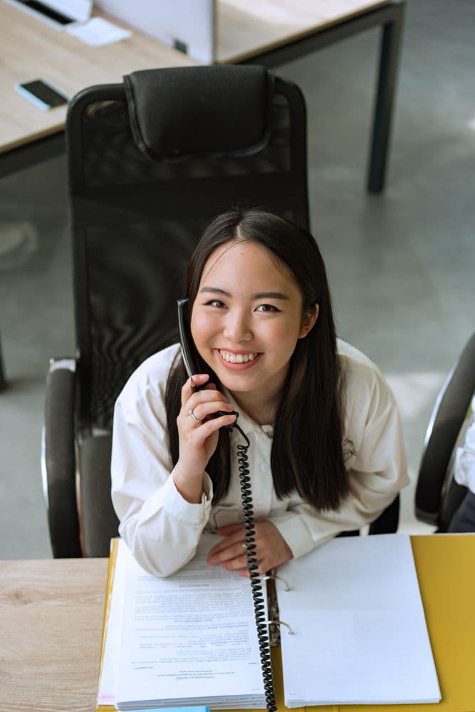 An office professional speaking on a desk phone